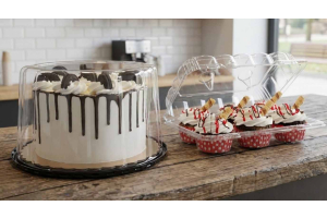 Professional bakery packaging for sale featuring a clear 6-count cupcake clamshell and a drip cake in a PET plastic dome on a rustic wooden counter.